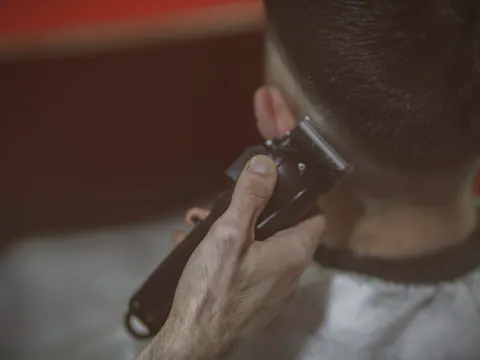 Clippers blending a skin fade at the temple